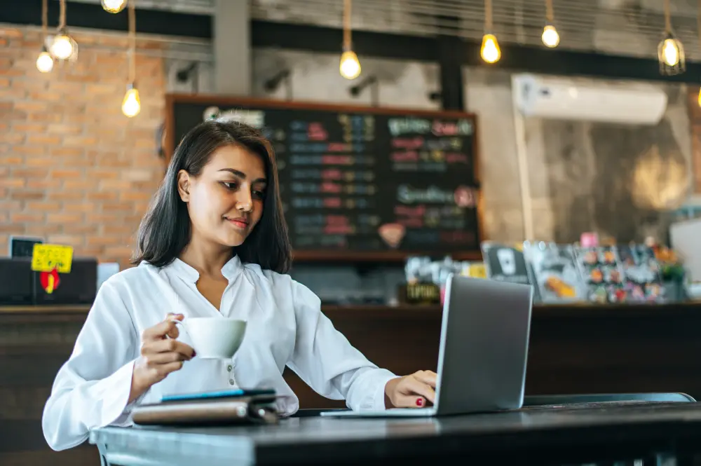 woman sitting working with laptop coffee shop