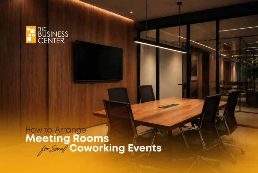 A modern, well-lit meeting room setup with a wooden table and black ergonomic chairs, ideal for small coworking events at The Business Center.